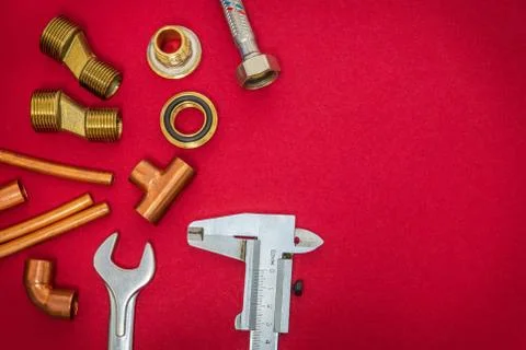 Set of tools and spare parts for plumbing on red background with space for ad Stock Photos