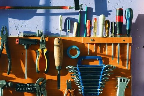 A set of tools carpenter or locksmith hanging on the wall. Background Foto stock