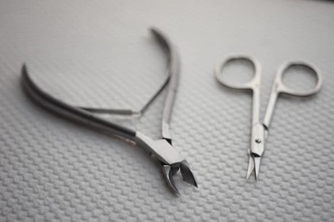 Set of tools for manicure on the table, cuticle nippers and scissors on a whi 스톡 사진