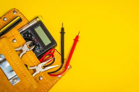 Set of tools in suede bag on yellow background prepared by the master electri Stock Photos