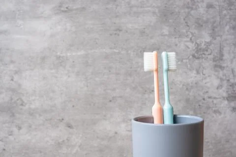 Set of Toothbrushes in cup on wall background at bathroom. World oral health  Stock Photos