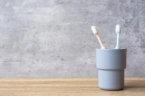 Set of Toothbrushes in cup on wall background at bathroom. World oral health  Stock Photos