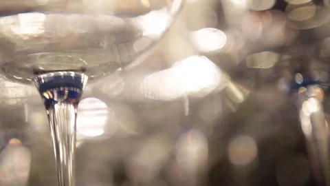 Set of transparent wine glasses sparkling with bokeh lights. Slow motion. Stock-Footage 72603233