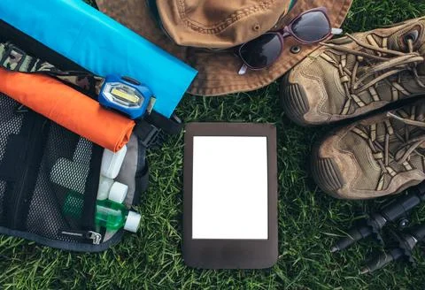 Set of trip stuff on green grass, flat lay Stock-Fotos