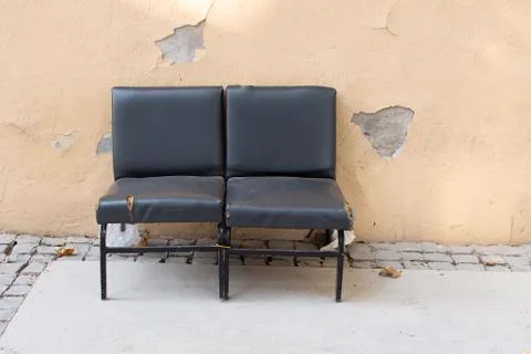 Set of two abandoned old leather chairs in the street Stock Photos