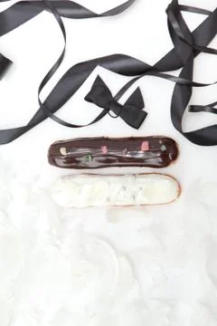 Set of two eclairs with a decor of black and white chocolate isolate on a whi Stock Photos