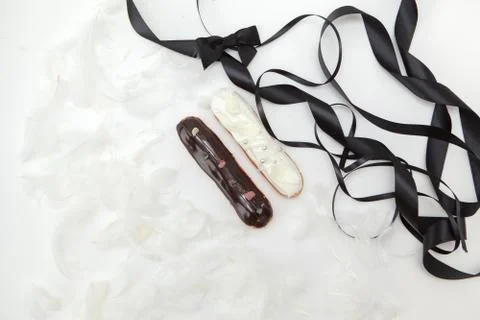 Set of two eclairs with a decor of black and white chocolate isolate on a whi Stock Photos