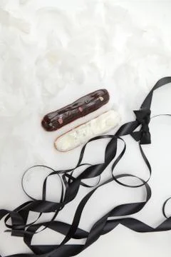 Set of two eclairs with a decor of black and white chocolate isolate on a whi Stock Photos
