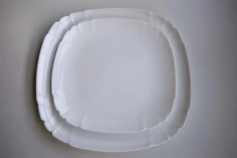 Set of two white ceramic glossy plates folded together isolated over a white Stock Photos
