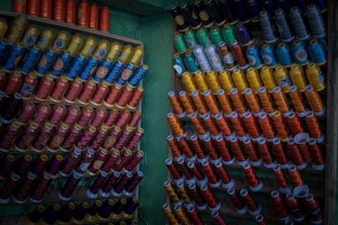 Set of various colorful threads placed on organizer on both sides of the wall Stock Photos