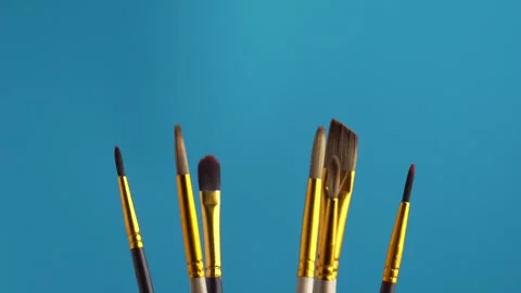 Set of various professional paint brushes rotating on a blue background, ma.. Stock Footage 247548649