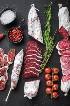 Set of various spanish dry cured salami sausages slices and whole cuts on balck Stock Photos