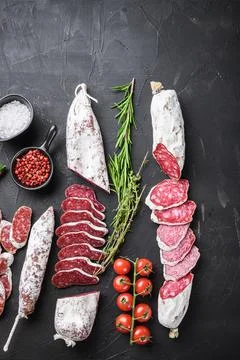 Set of various spanish dry cured salami sausages slices and whole cuts on bal Stock Photos