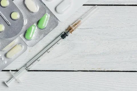 Set of Various Tablets, Capsules in Blisters, Syringe on White Wooden Background Stock Photos