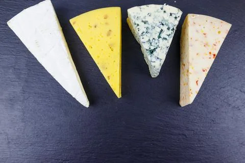 Set of various types of cheese on black slate background. Top view Stock Photos