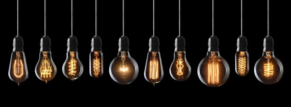 Set of vintage glowing light bulbs on black background Stock Photos