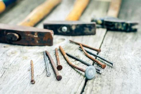 Set of vintage hand construction tools hammers with nails on a wooden backgro Stock Photos