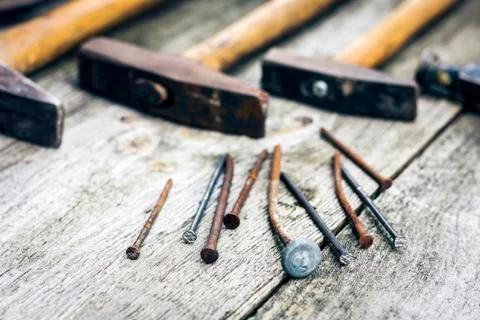 Set of vintage hand construction tools hammers with nails on a wooden backgro Stock Photos