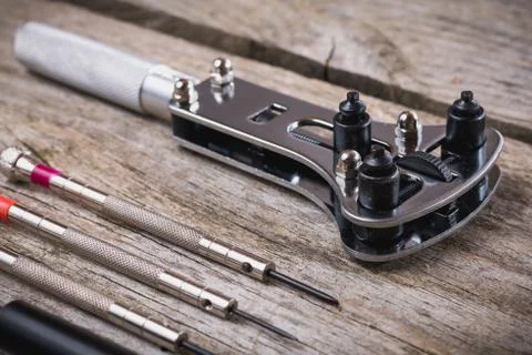 Set of watchmaker tools isolated on a rough wooden board Stock Photos