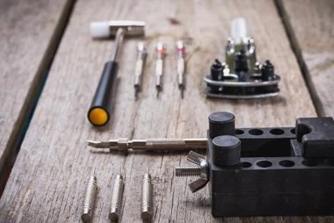 Set of watchmaker tools isolated on a rough wooden board Stock Photos