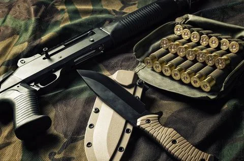 Set of weapons of a fighter of a special unit. Shotgun, cartridges, knife. .. Stock Photos