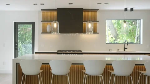 Set of white bar stools standing next to table in row in kitchen with overhead Stock Footage 280419208