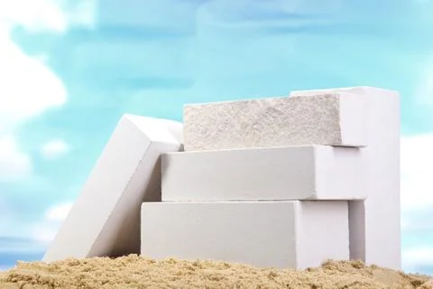 Set of white ceramic bricks on the sand at the blue sky background Stock Photos