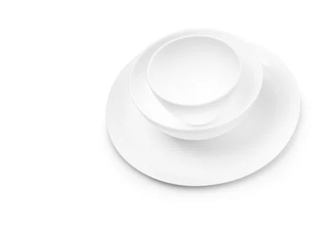 Set of white dishes on table on light background. Stock Photos