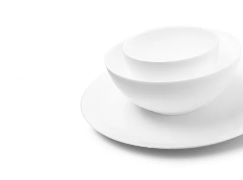 Set of white dishes on table on light background. Stock Photos