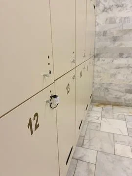 Set of white locker with one door open and blue towel in school restroom Stock Photos