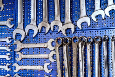 A set of worn combination wrenches and box-ends wrenches. Utensils hanging on Stock Photos