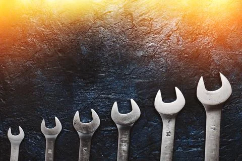 Set of wrenches background of wall illuminated by sun. Stock Photos