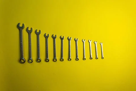 Set of wrenches of different sizes on a yellow background Stockfoto's