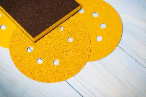 Set of yellow abrasive tools and a sandpaper on wooden blue boerds Stock Photos