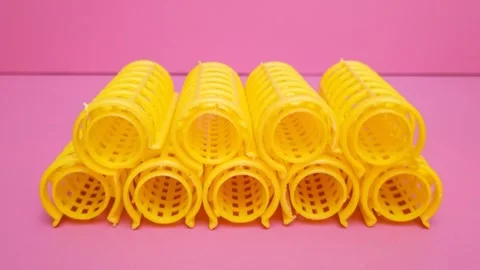 Set of Yellow Hair Rollers moving on Pink Background, Heatless Hair Curlers Stock Footage 346672983