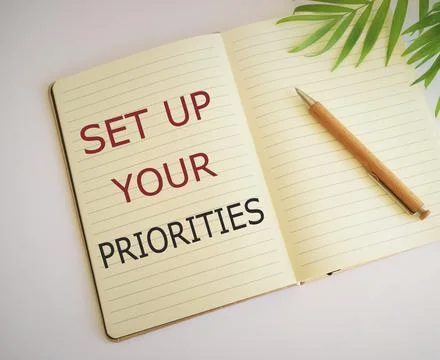 Set up your priorities text written in Notebook. Business concept Stock Photos