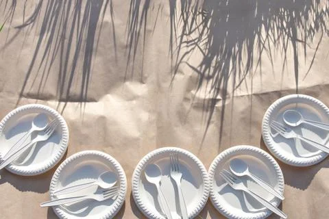 Sets of disposable biodegradable glassware on craft paper in nature. Фото