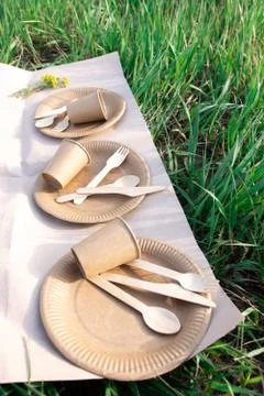 Sets of disposable biodegradable tableware on craft paper in nature. Stock-Fotos