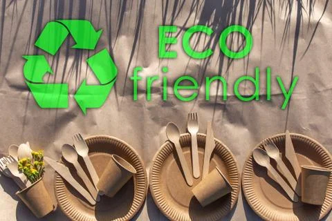 Sets of disposable biodegradable tableware on craft paper in nature. Stock Photos