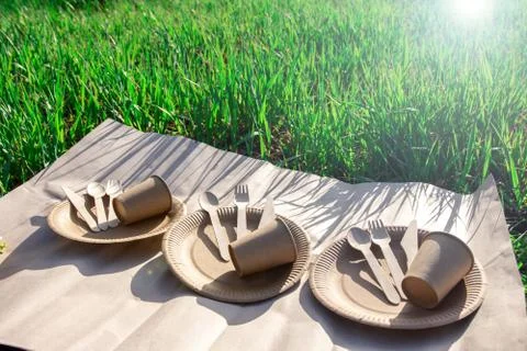 Sets of disposable biodegradable tableware on kraft paper in nature. Stock Photos