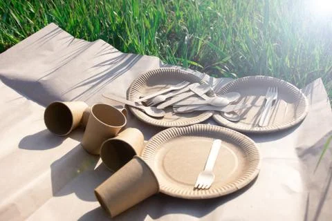 Sets of disposable biodegradable tableware on kraft paper in nature. Stock Photos