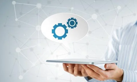 Setting application icon Hands of businessman showing tablet with gear ico... Stock Photos