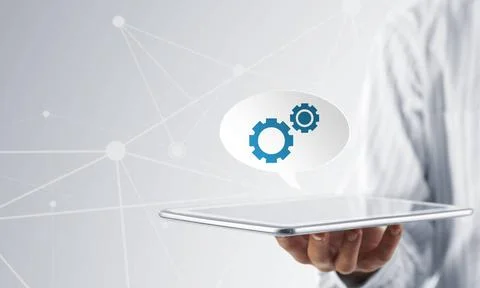 Setting application icon Hands of businessman showing tablet with gear ico... Stock Photos