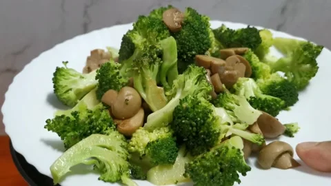 Setting Aside Steamed Broccoli Florets and Mushroom Stock Footage 234882576
