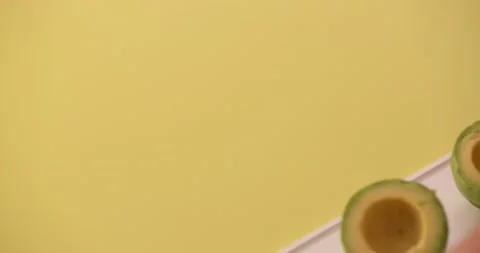 Setting avocados on a cutting board down 3 Stock Footage 132136665