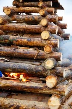 Setting big bonfire made of logs on fire with torch. Foto stock