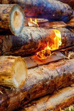 Setting big bonfire made of logs on fire with torch. Foto stock