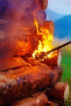 Setting big bonfire made of logs on fire with torch. Foto stock