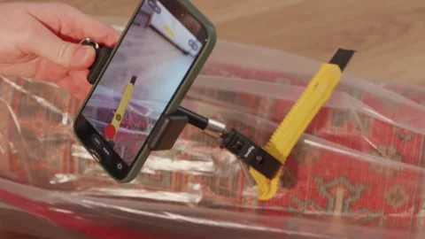 Setting up camera on magic arm next to utility knife on floor Stock Footage 346159490