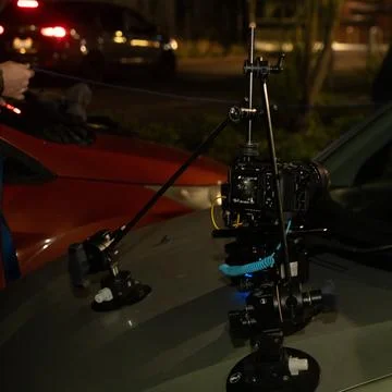 Setting up a camera on top of a tripod to keep it stable on a car. Stock-Fotos